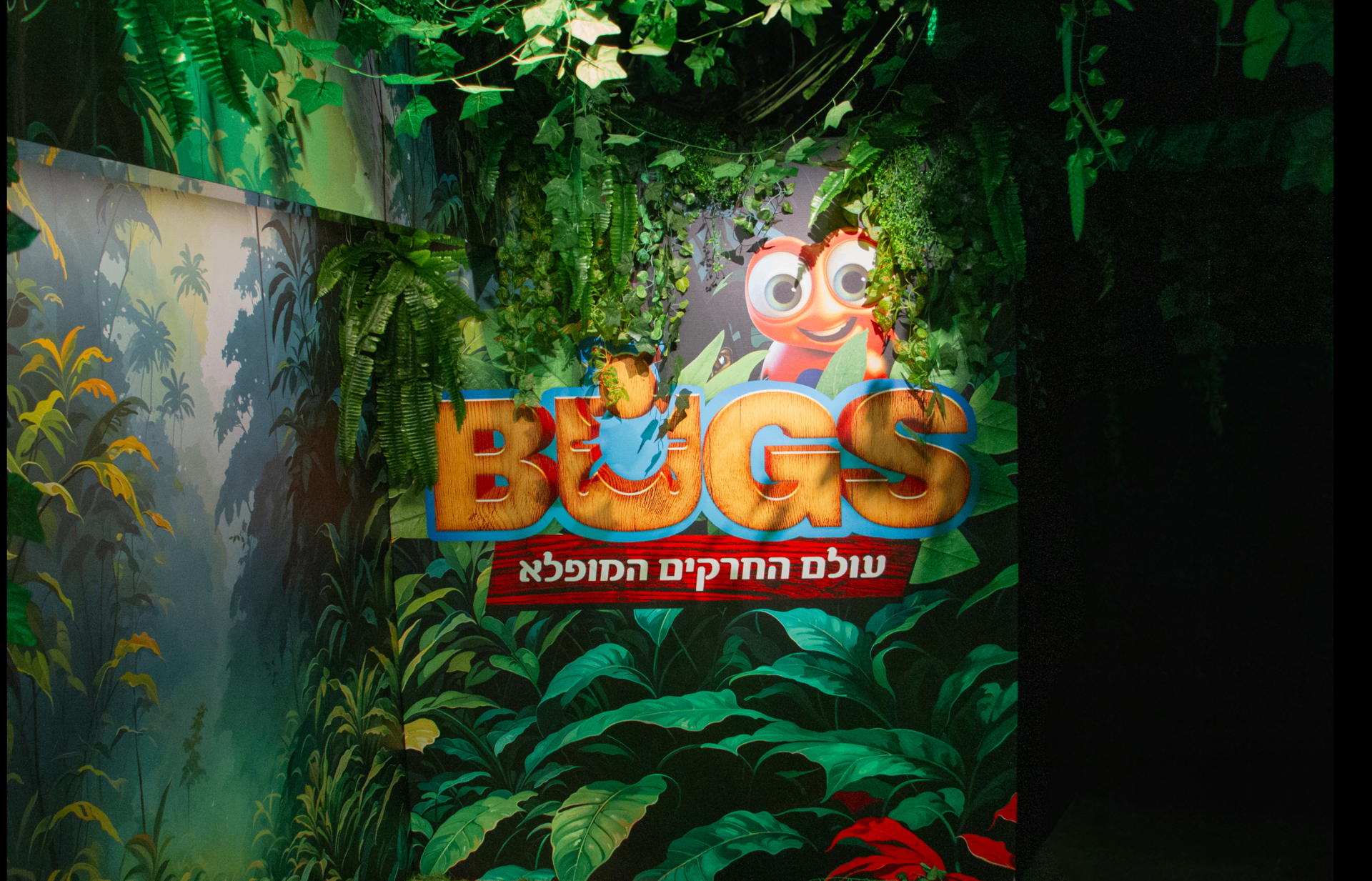 Bugs World sign surrounded by greenery in the installation space
