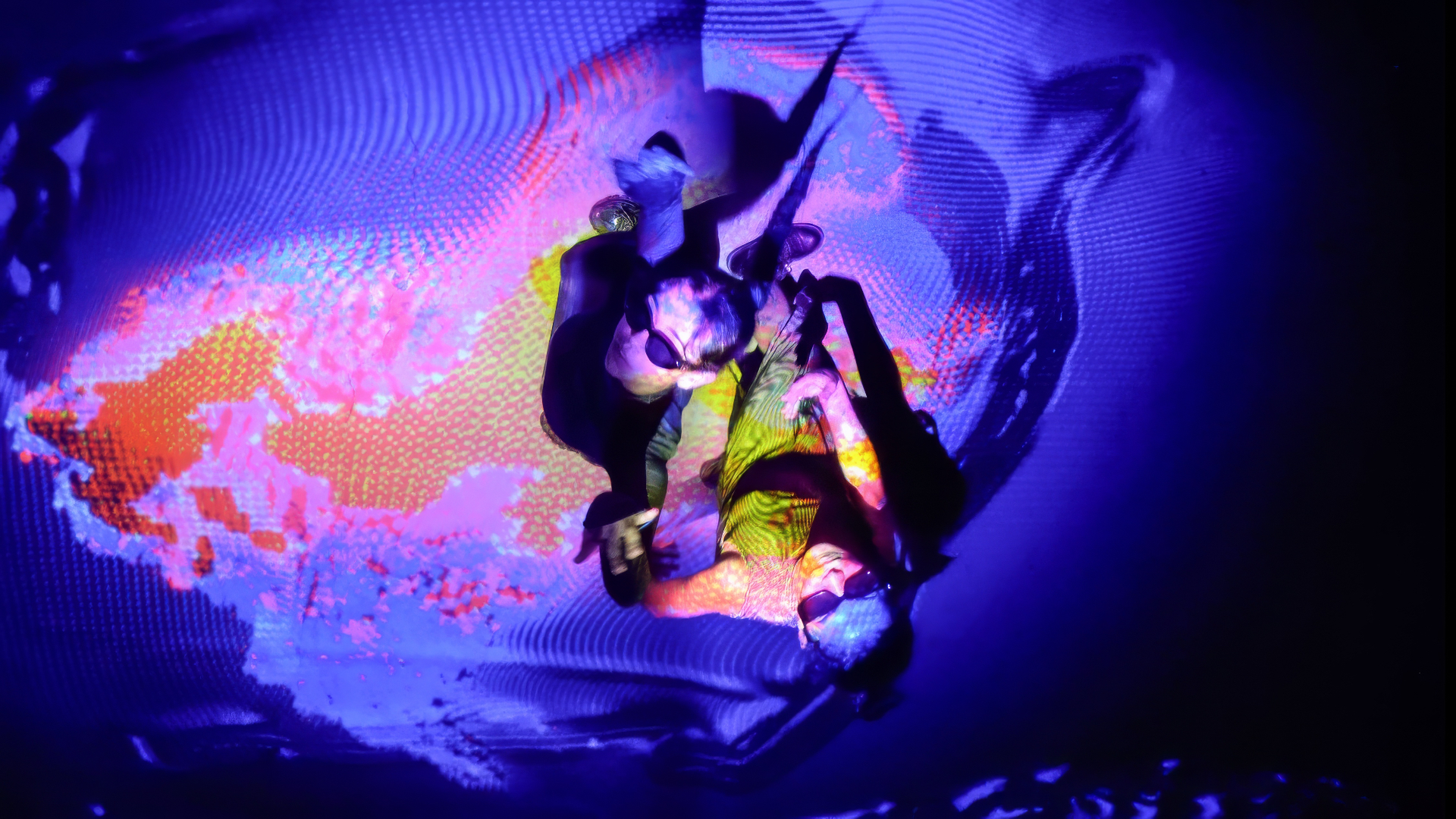 Overhead view of two people inside a purple and orange light pattern