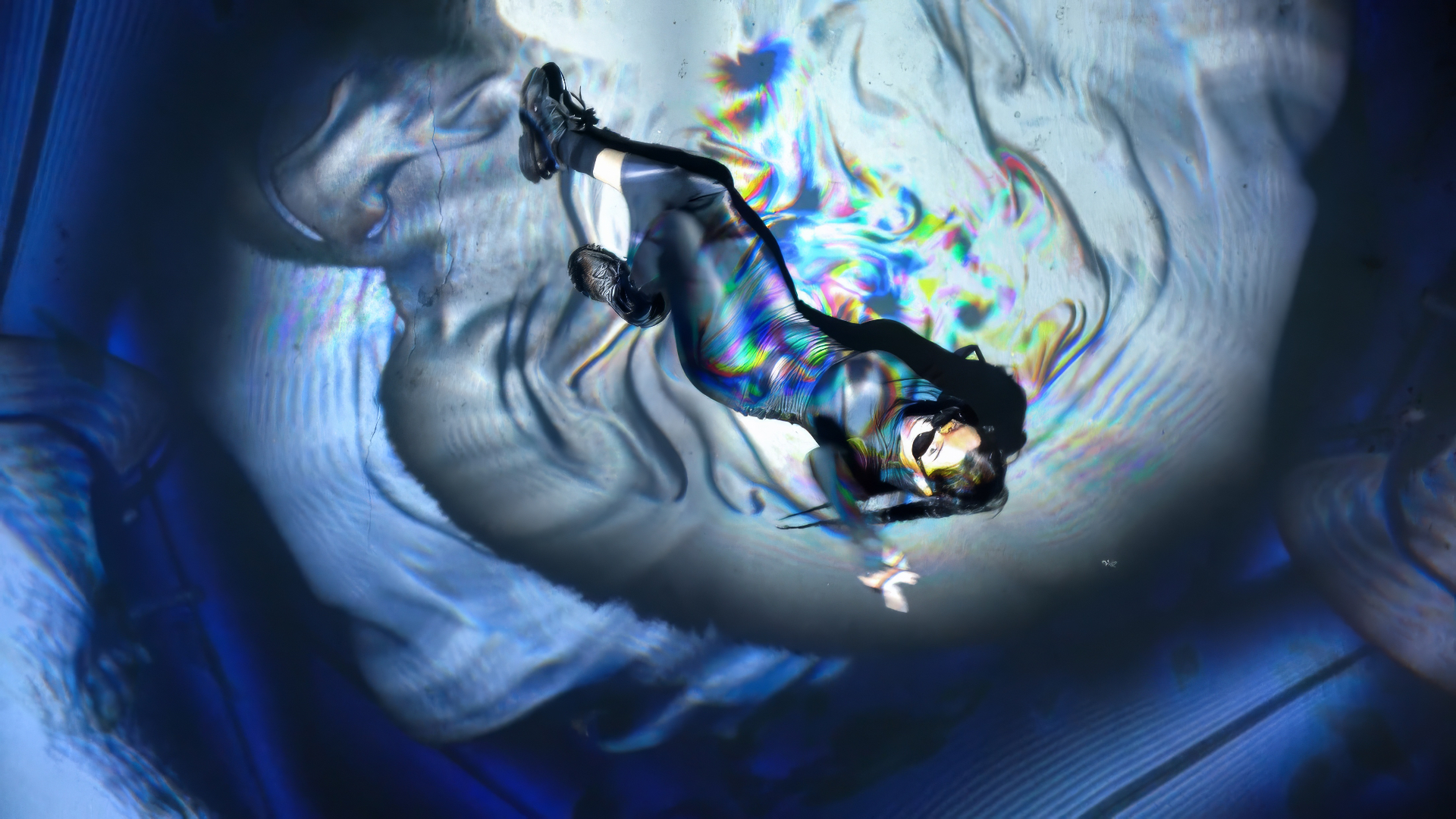 A person lying on the floor within a wavy blue and white projection