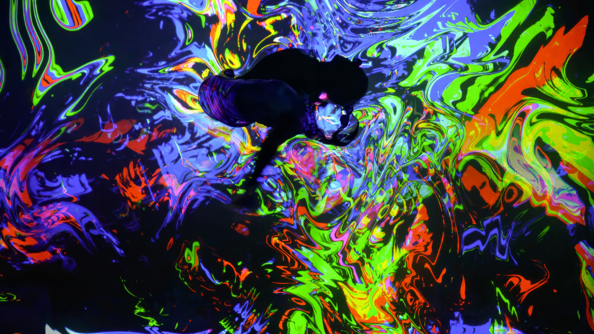 A person photographed from above against winding colorful patterns
